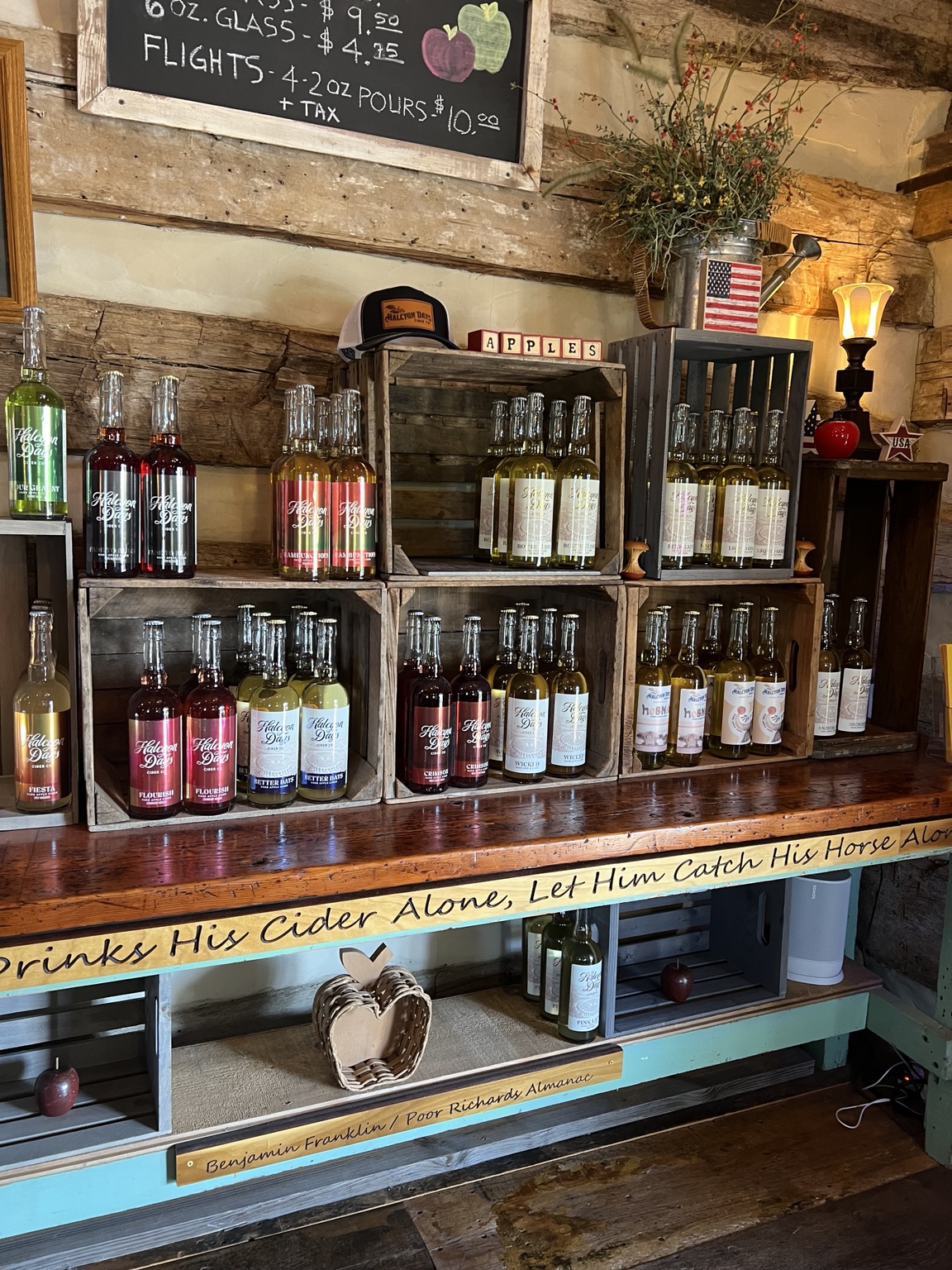 Bottles of Halcyon Days cider displayed inside the rustic tasting room.