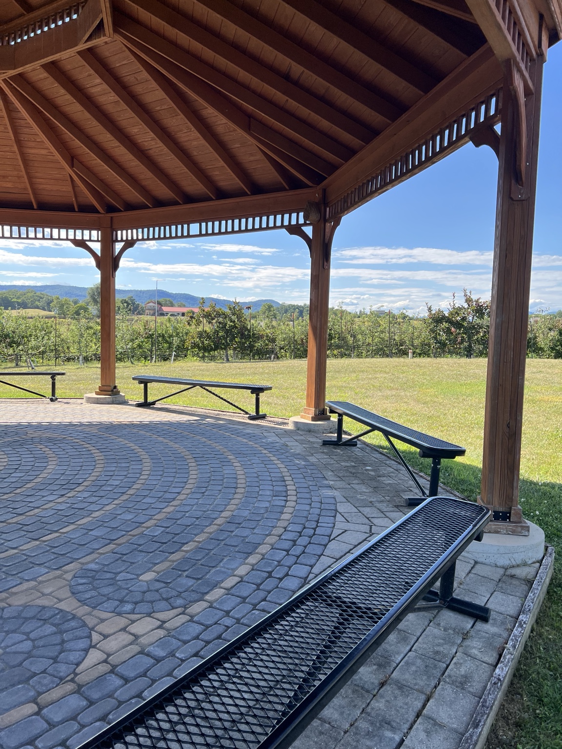 Stone labyrinth pattern beneath the open-air gazebo overlooking the orchard.