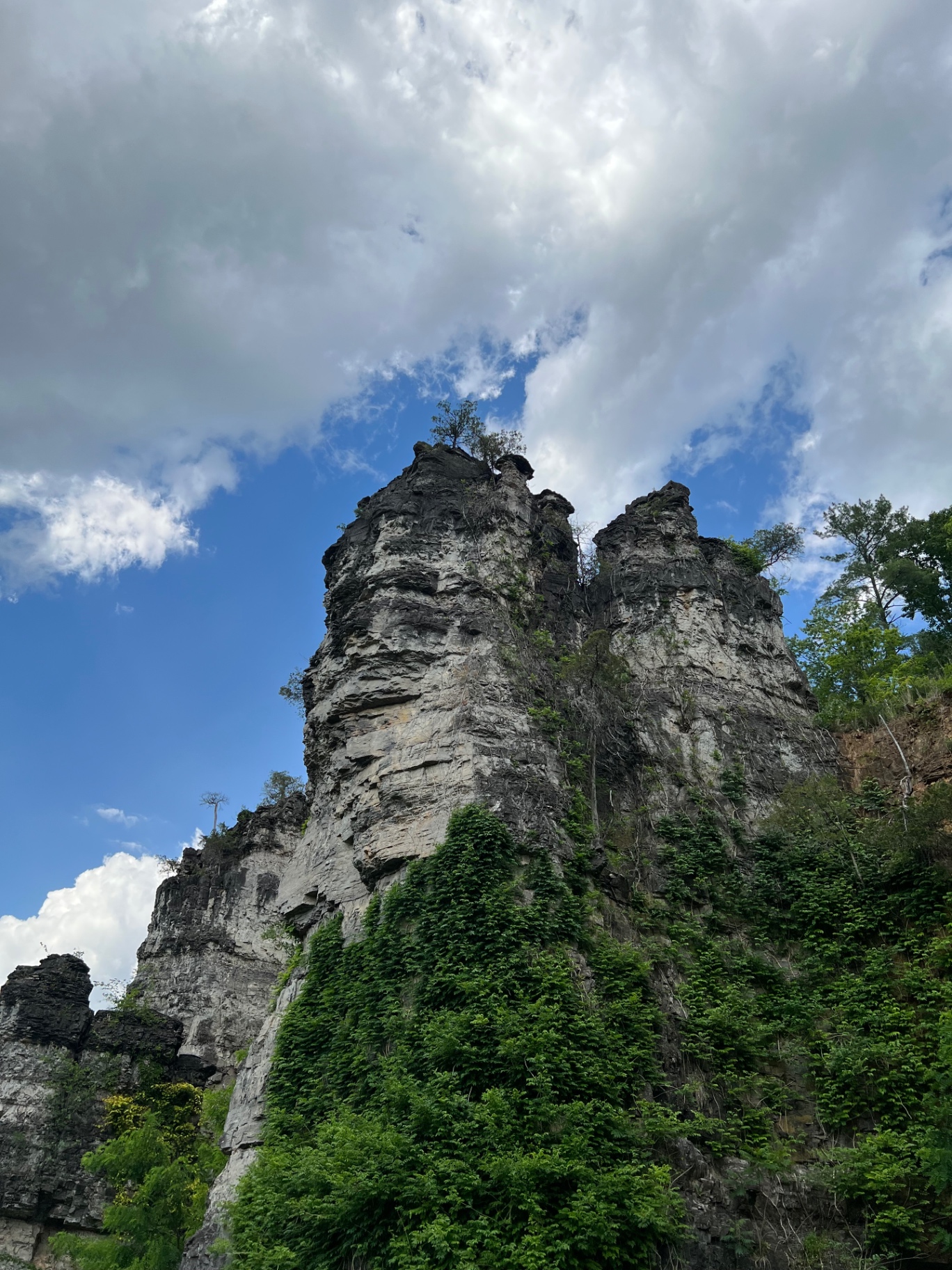 Looking up at the towering limestone chimneys against a bright cloudy sky