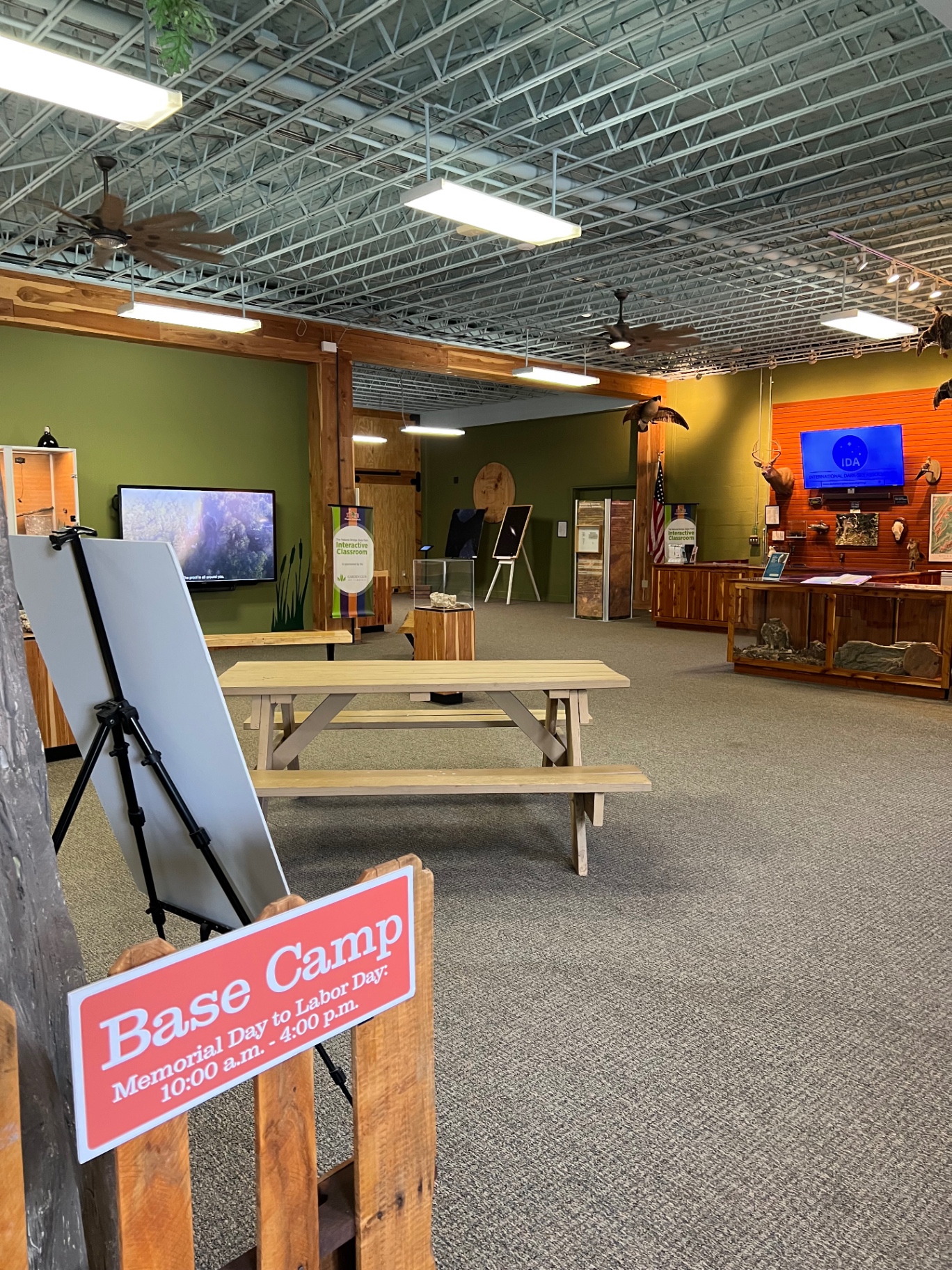 Interior of the Base Camp interpretive area with a picnic table, exhibits, and wildlife displays inside the gift shop